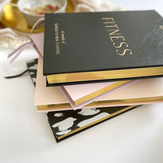 The Daily Fitness Planner covers 365 days of workout and meal planning. The fitness planner has an elegant vegan leather cover with 3 pages of gold stickers. 208 pages of fitness, meal planning, motivation and tracking. Hardback binding with foiled gilt edging to the pages. 165mm (W) x 210mm (H)