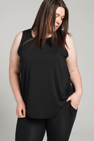 Well Fit Activewear. Female model wears long length, drop-arm gym vest and black compression leggings to the ankle. Well Fit tops and leggings are available in UK sizes 8 to 30. Free shipping over £100.
