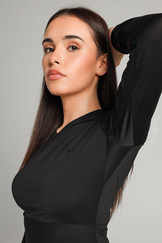 Well Fit Activewear. Female model wears black, lightweight, long sleeve, tunic-style gym top with black gym leggings. Well Fit tops and leggings are available in UK sizes 8 to 30. Free shipping over £100. Jasmine, model, lifts arms to reveal the sweat-wicking, breathable panels in the arm pits of the black Well Fit gym top.
