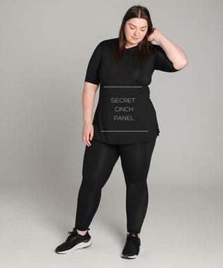 Well Fit Activewear. Female model wears black, lightweight, short sleeve, tunic-style gym top with black gym leggings. Well Fit tops and leggings are available in UK sizes 8 to 30. Free shipping over £100.