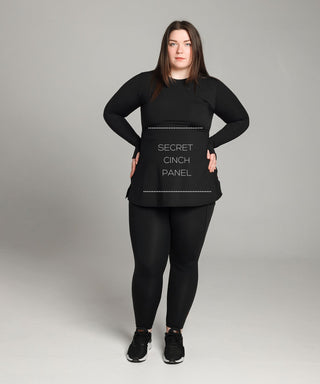 Well Fit Activewear. Female model wears black compression gym top in a longer length tunic style and black compression leggings to the ankle. Well Fit tops and leggings are available in UK sizes 8 to 30. Free shipping over £100.