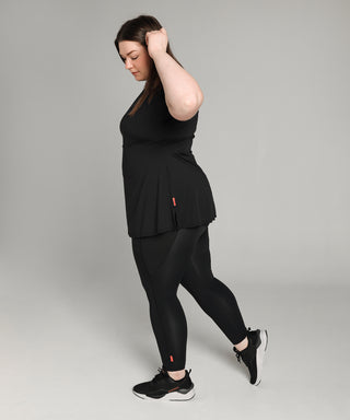 Well Fit Activewear. Female model wears black compression gym top in a longer length tunic style and black compression leggings to the ankle. The leggings have a pocket on each leg that is big enough for phone, keys, debit card, even a banana as well! Well Fit tops and leggings are available in UK sizes 8 to 30. Free shipping over £100.