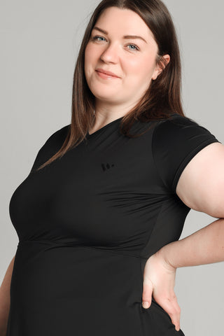 Well Fit Activewear. Female model wears black, lightweight, tunic-style gym top with black gym leggings. Well Fit tops and leggings are available in UK sizes 8 to 30. Free shipping over £100. Grace, plus size model, is a UK size 20,
