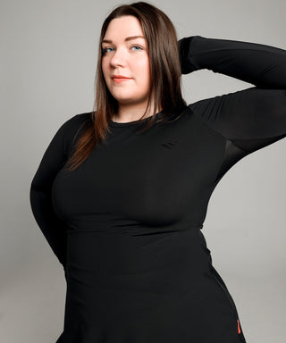 Grace, model, lifts arms to reveal the sweat-wicking, breathable panels in the arm pits of the black Well Fit gym top.