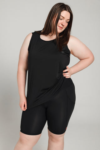Well Fit Activewear. Female model wears black compression shorts that fall above the knee. The shorts have a pocket on each leg that is big enough for phone, keys, debit card, even a banana as well! Well Fit tops and shorts are available in UK sizes 8 to 30. Free shipping over £100. Grace wears a UK size 20. She is in black Well Fit vest and black Well Fit compression shorts.