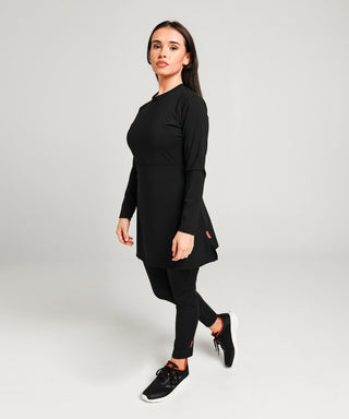 Well Fit Activewear. Female model wears long sleeve black compression gym top in a longer length tunic style and black compression leggings to the ankle. Well Fit tops and leggings are available in UK sizes 8 to 30. Free shipping over £100.
