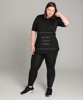 Well Fit Activewear. Female model wears black, lightweight, short sleeve, tunic-style gym top with black gym leggings. Well Fit tops and leggings are available in UK sizes 8 to 30. Free shipping over £100.