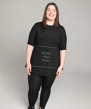 Well Fit Activewear. Female model wears short sleeve black compression gym top in a longer length tunic style and black compression leggings to the ankle. Well Fit tops and leggings are available in UK sizes 8 to 30. Free shipping over £100.